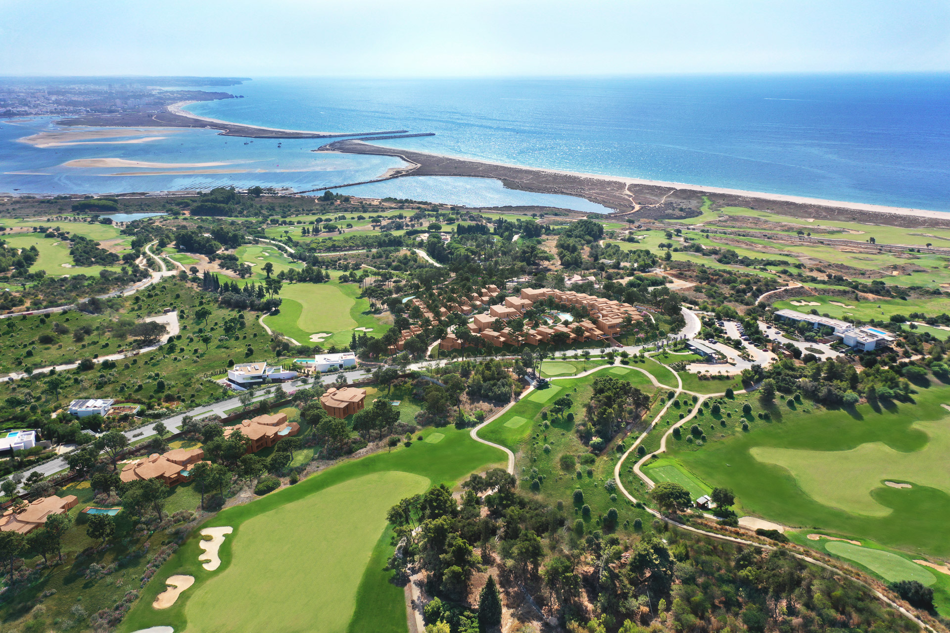 Palmares fairway and bunker with resort residences, the Alvor Estuary and ocean beyond